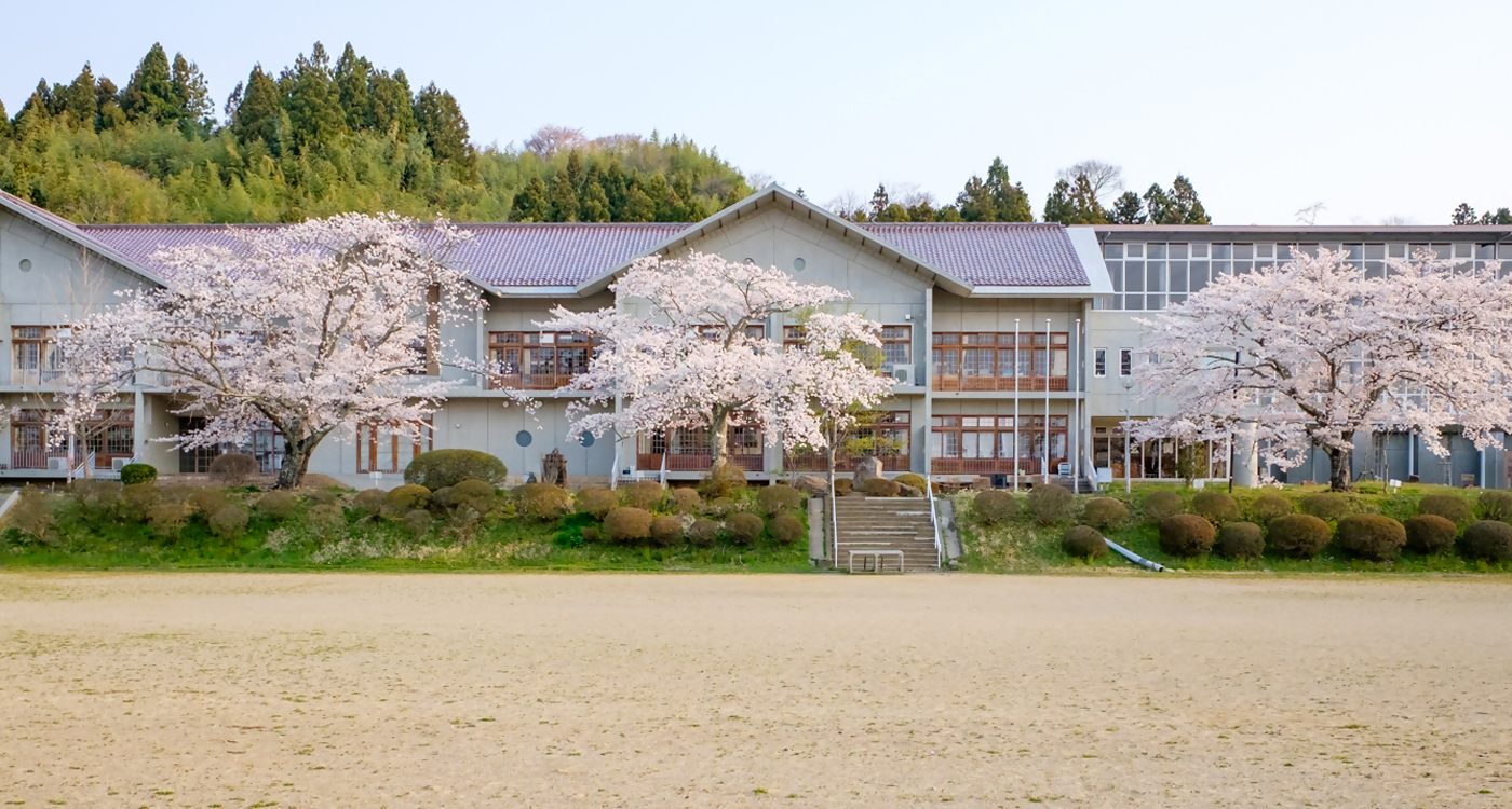 桜に包まれる栗駒小学校の春の画像