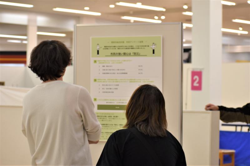 来場者が展示しているパネルを見ている様子の写真