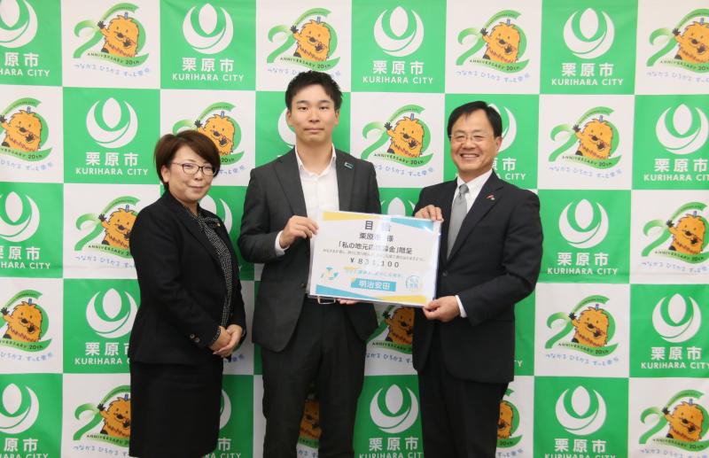 登米営業所長と佐藤市長が目録を持って写真を撮っている様子。