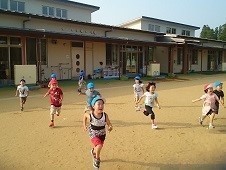 園庭を駆ける園児の写真